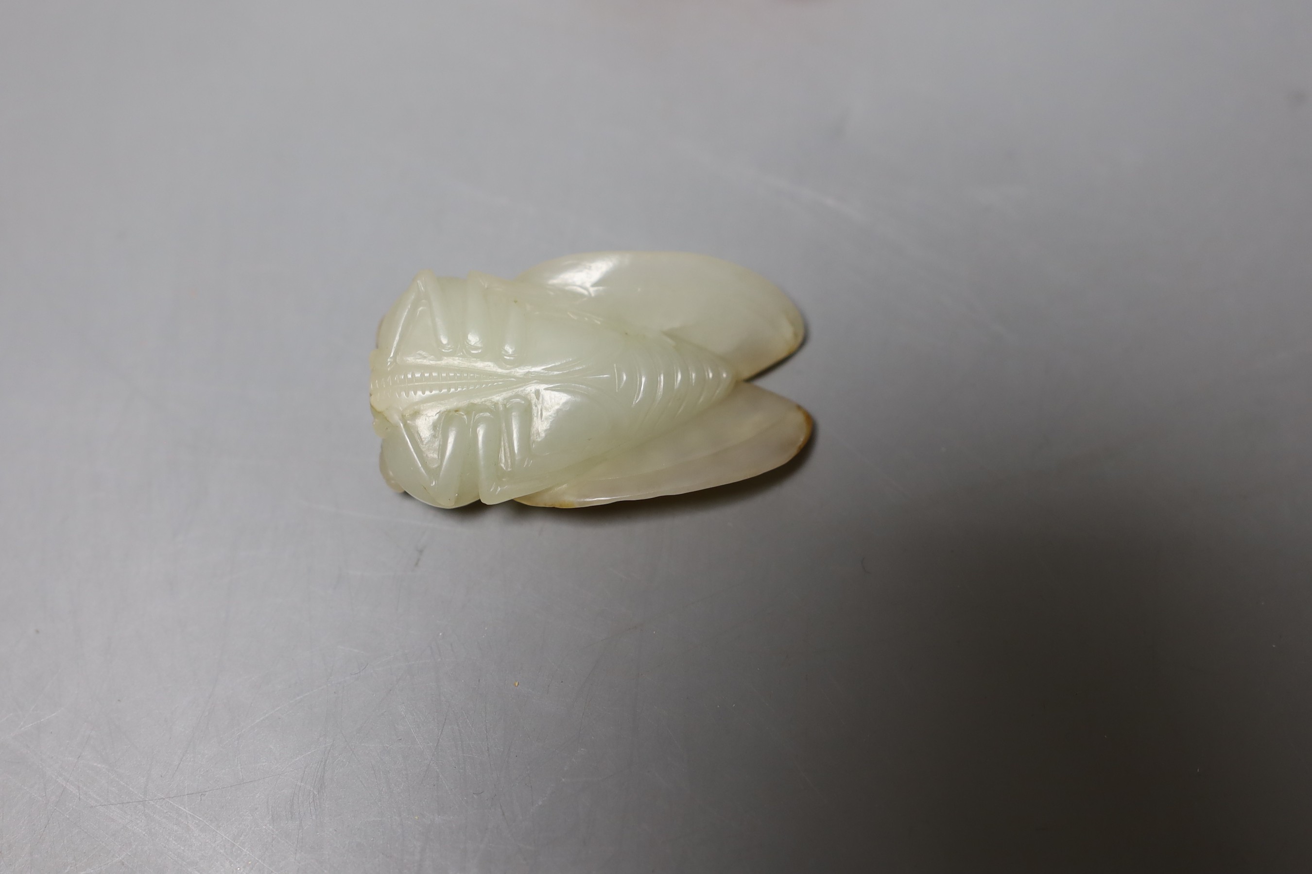 A 19th century Chinese pale celadon and russet jade carving of a cicada, 4.9cm, together with three other hard stone figures and two Japanese earthenware figures (6)